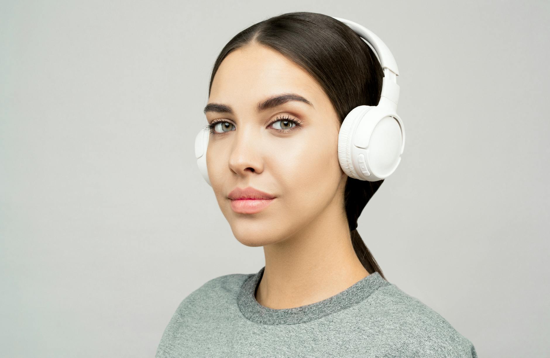 woman in gray crew neck shirt wearing white headphones